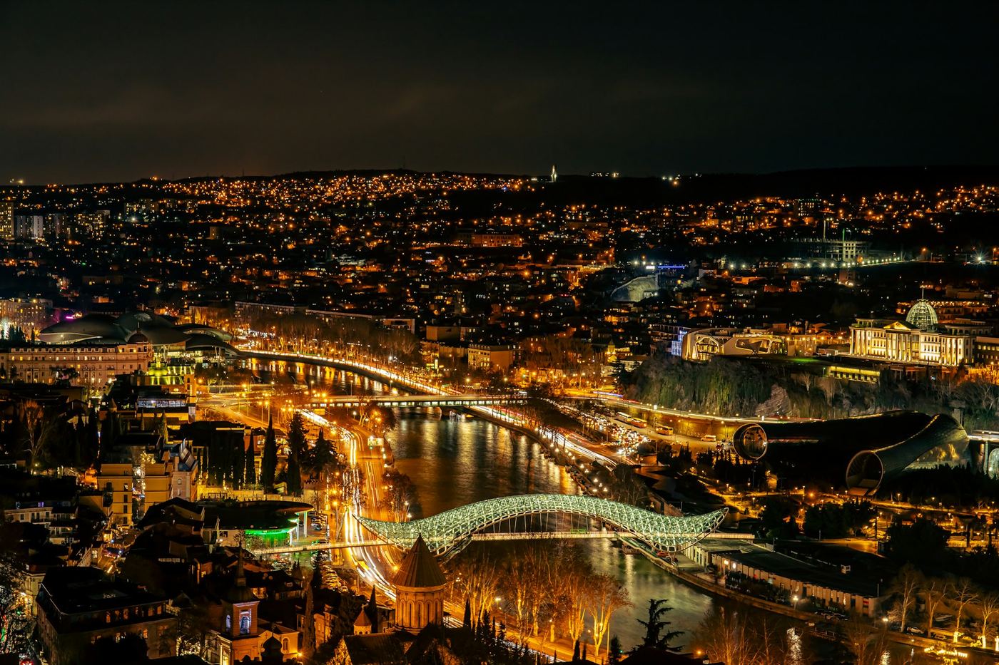Tbilisi at night, with the Mtkvari river and the Bridge of Peace